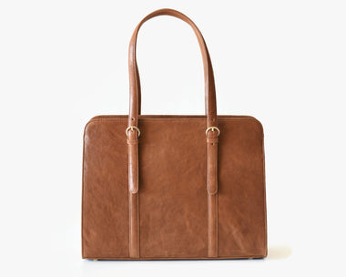 A caramel brown leather laptop bag with two handles and a detachable shoulder strap.
