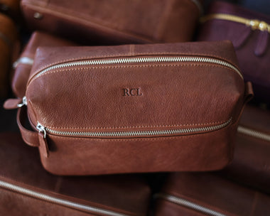 Full grain leather toiletry dopp kit with a blind hot stamped monogram and silver zipper